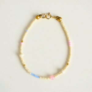 Jasna, delikatna bransoletka z koralików z pozłacanym zapięciem.